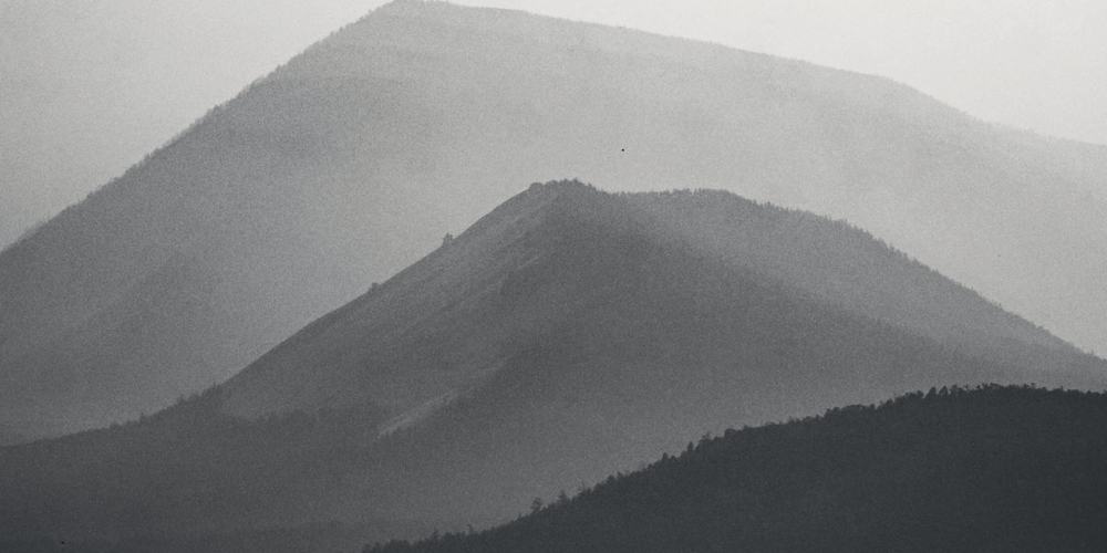 A hillside seen through heavy fog, its outline barely readable