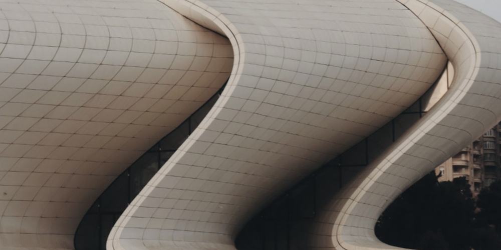 A pale curved building against an open sky