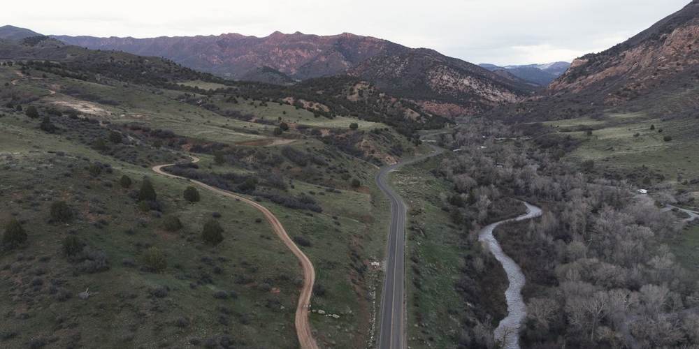 A road and a river running together down a wide valley, seen from above