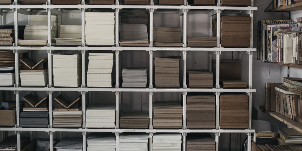 Rows of box files on open shelving, seen straight on