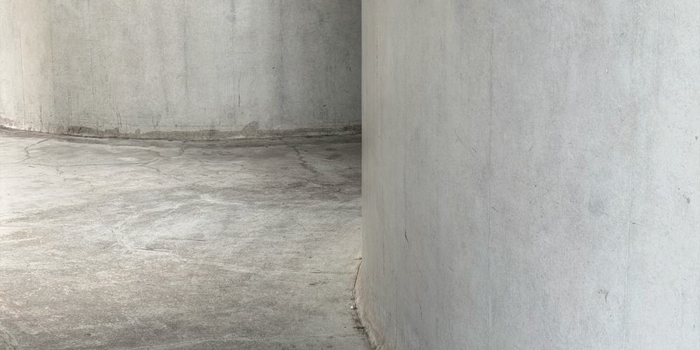 A curved concrete wall meeting a plain floor in low light