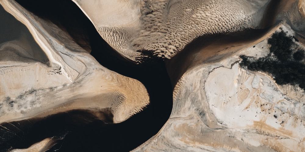 A river delta from the air, channels branching through pale sand