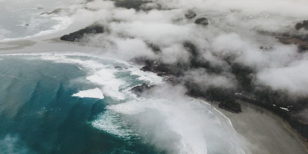 A coastline from the air, pale shallows meeting darker water