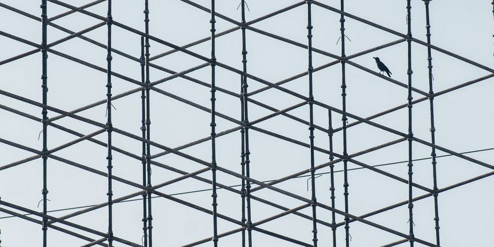 A lattice of scaffolding seen against an open sky
